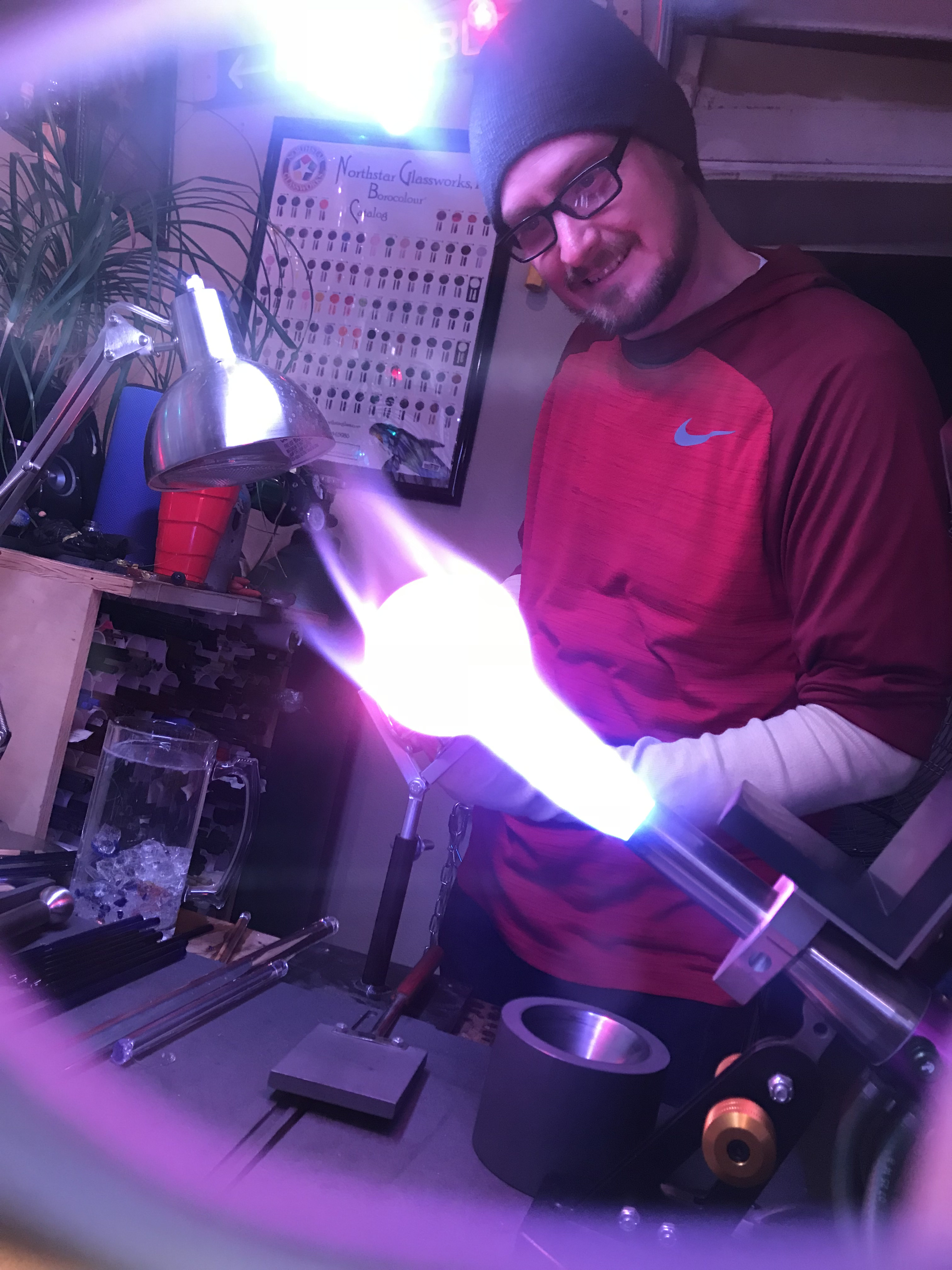 Will Stuckenberg shaping glass in a bright torch flame