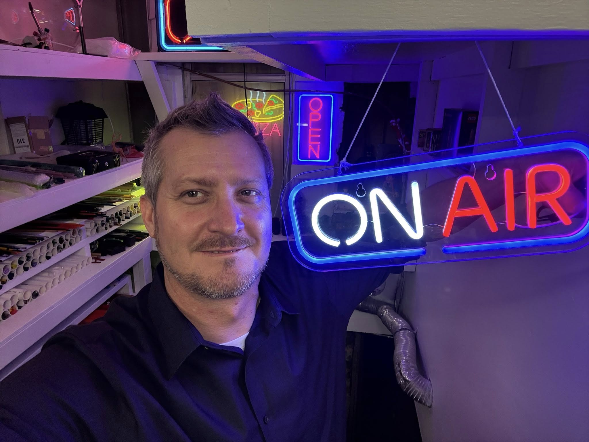 Will Stuckenberg holding an On Air sign in the studio
