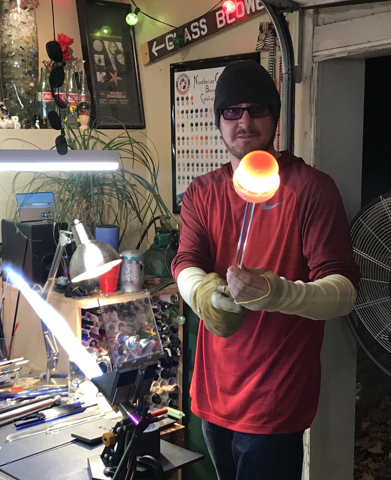 Will Stuckenberg holding a glowing gather of hot glass