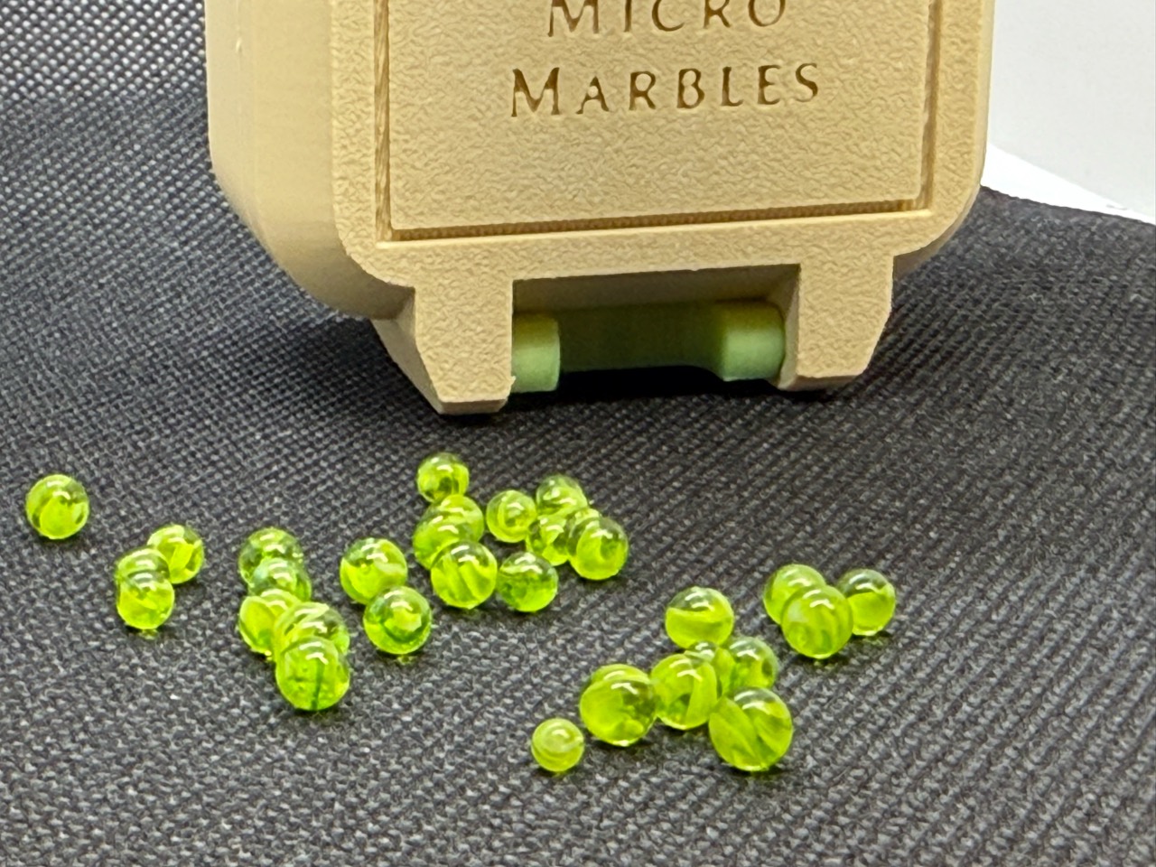 Close view of individual neon green Micro Marbles with swirling glass details
