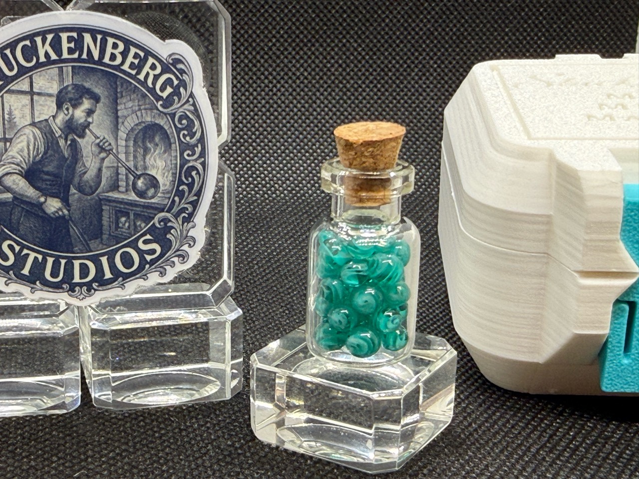 A corked bottle of teal Mini Micro Marbles from Stuckenberg Studios
