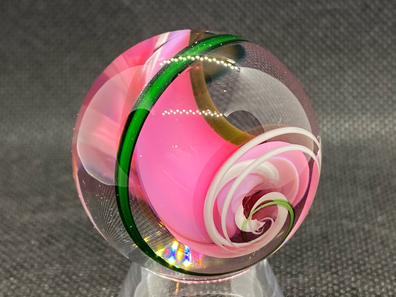 Bright Pink Gold Fume Spiral Marble: Close view of the bright pink spiral with a green band and curling white ribbons