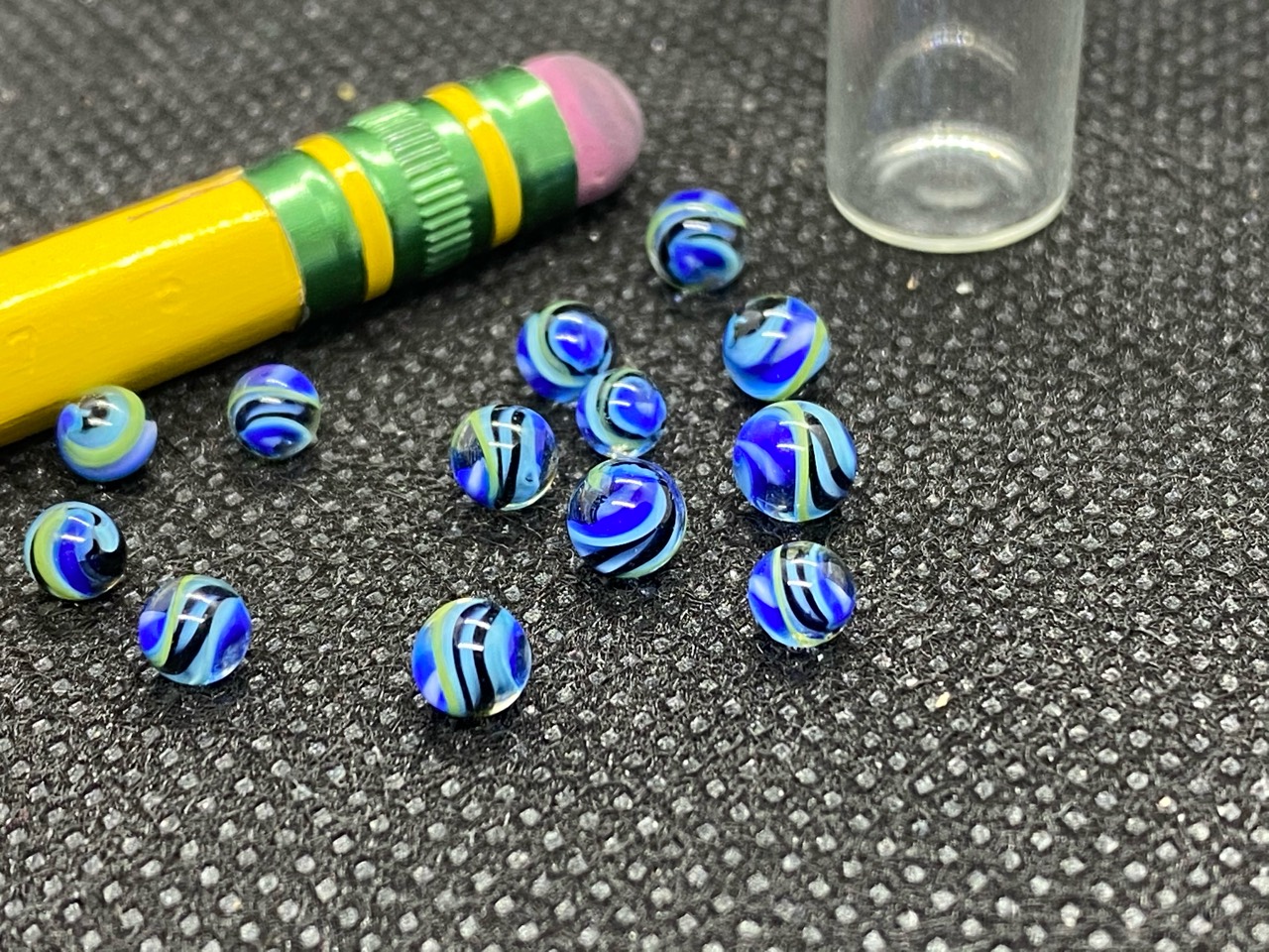 Cobalt & Aqua Ribbon Mini Micro Marbles: Close group view of blue ribbon micro marbles beside a pencil eraser for scale
