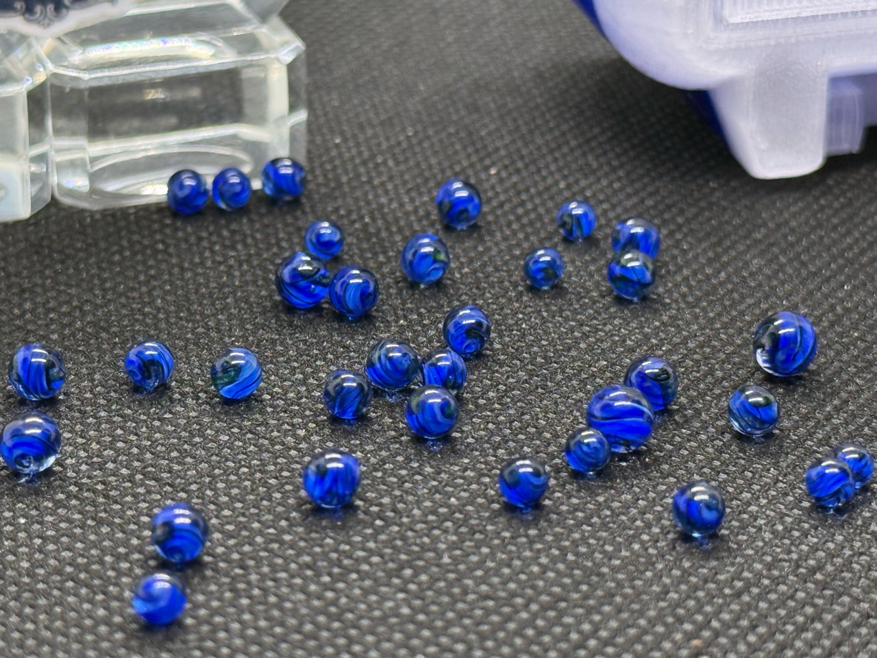 Close view of cobalt blue ribbons in loose Cobalt UV Uranium Glass Mini Micro Marbles in ordinary light
