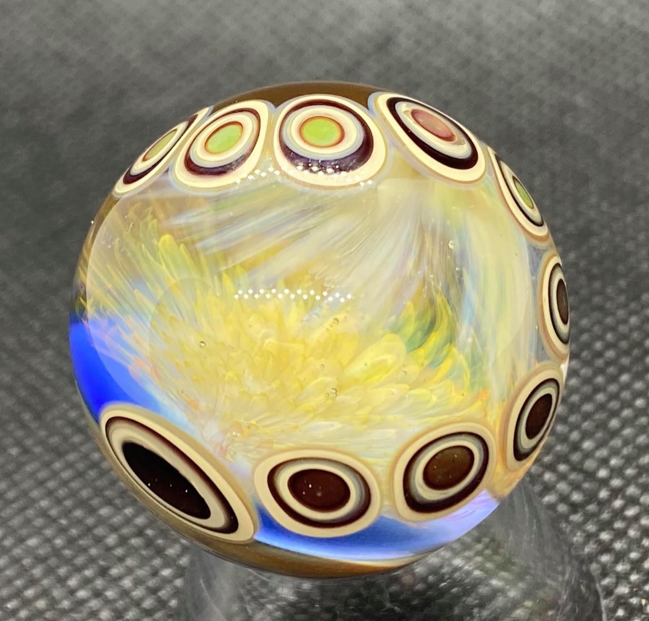 Dot Stack Marble with Double Fume Implosion: full angled view of layered golden blooms framed by cream and burgundy dot stacks