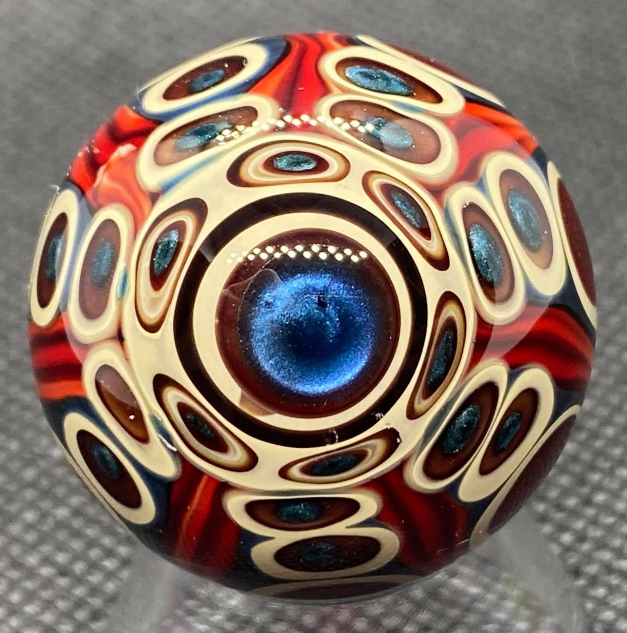 Dot Stack Marble — Over 160 Dots: full view of the sparkling blue center surrounded by cream-ringed dots and red ribbons