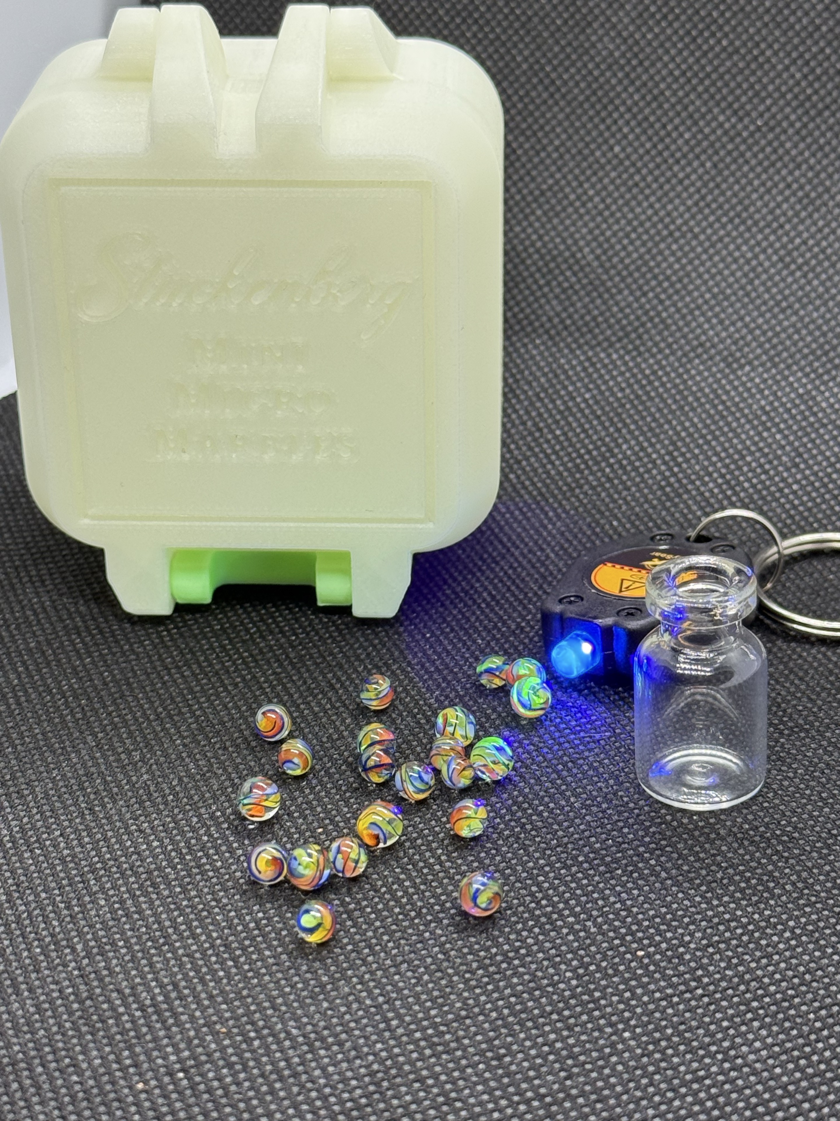 Electric Rainbow Mini Micro Marbles with their black light keychain, jar and pale display box