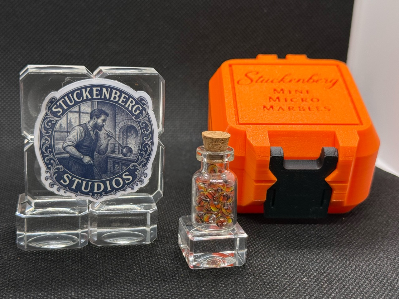Fine Line Flame marble jar beside studio branding and an angled orange hard case with a black latch
