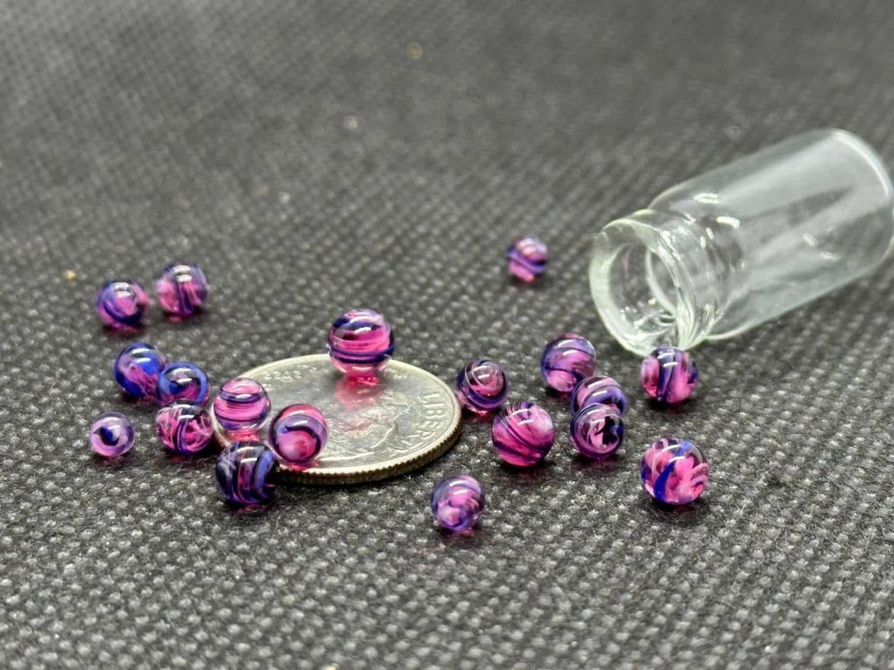 Galaxy Purple: pink and purple mini micro marbles arranged around and on a dime