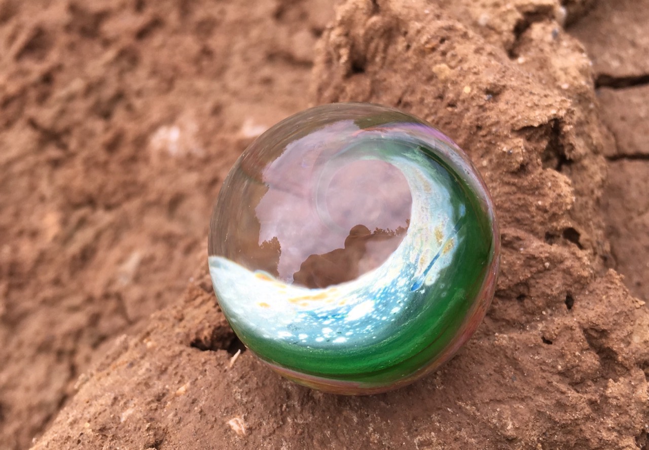 Green Ocean Space Wave: Full view of the green ocean curl with a pale blue-white crest wrapping around a clear central opening