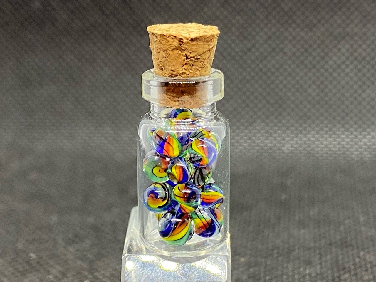 Legacy Rainbow Mini Micro Marbles: Upright corked bottle filled with the legacy rainbow Mini Micro Marbles