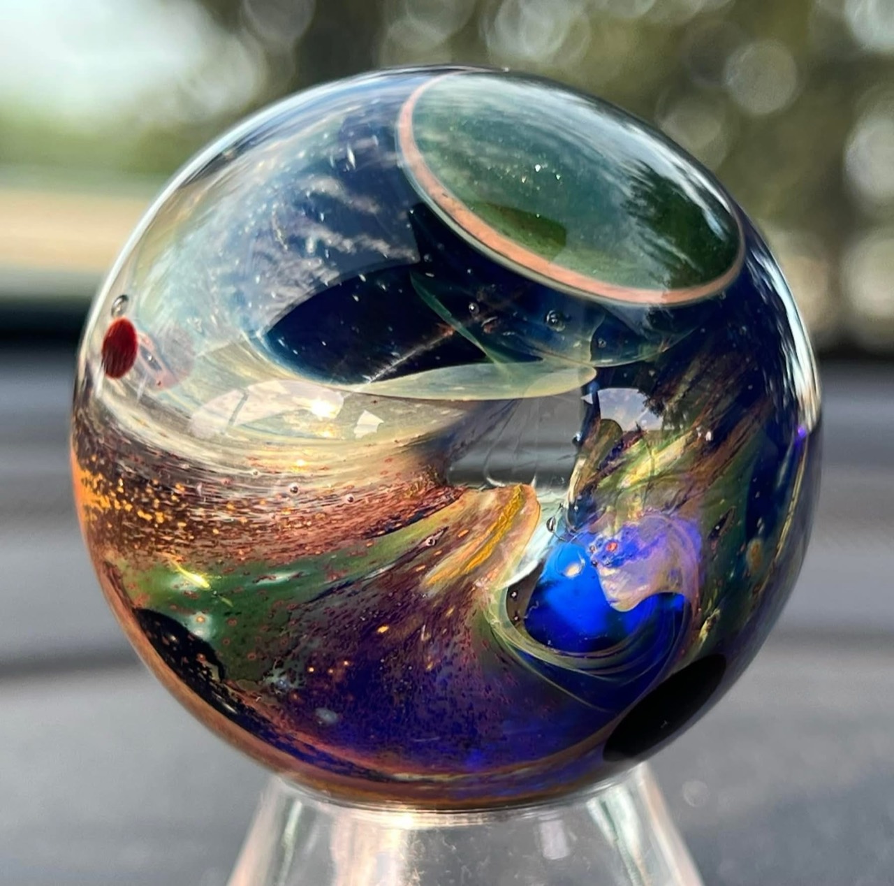 Living Planet Marble — June 27, 2022: green planet above deep blue space and sweeping copper-colored clouds