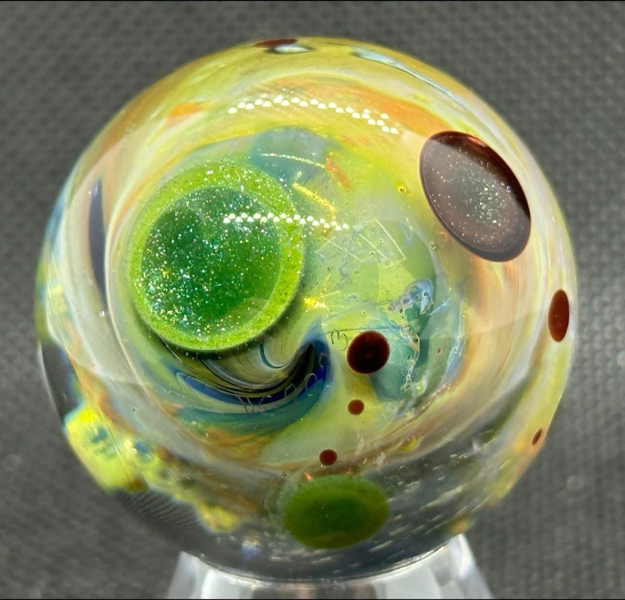 Living Planet Space Marble #3 (2023): sparkling green planet surrounded by golden currents and dark planet forms