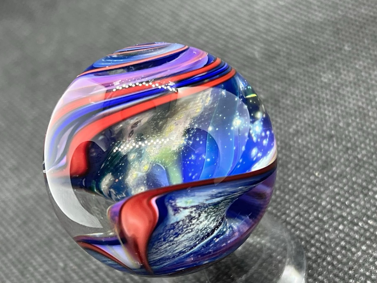 Parallel Dimension of Space Marble: blue space scene framed by sweeping coral-red and lavender bands