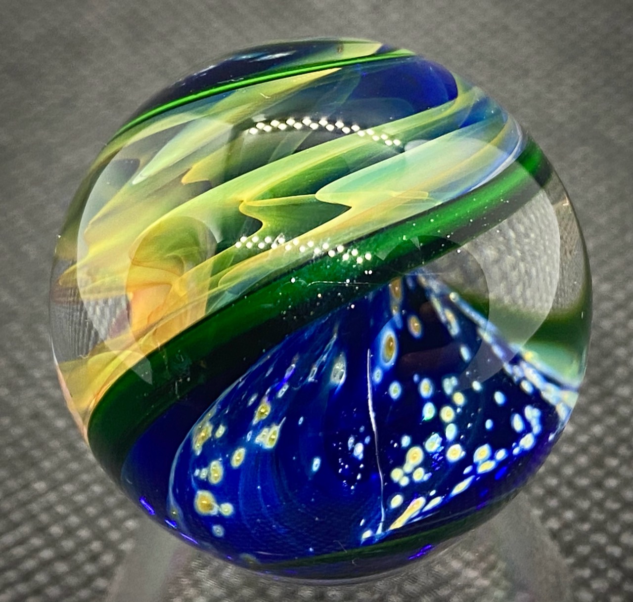 Parallel Dimensions of Space Marble — 2020: Side rotation showing yellow-green fume currents above blue space scattered with luminous pale and golden details