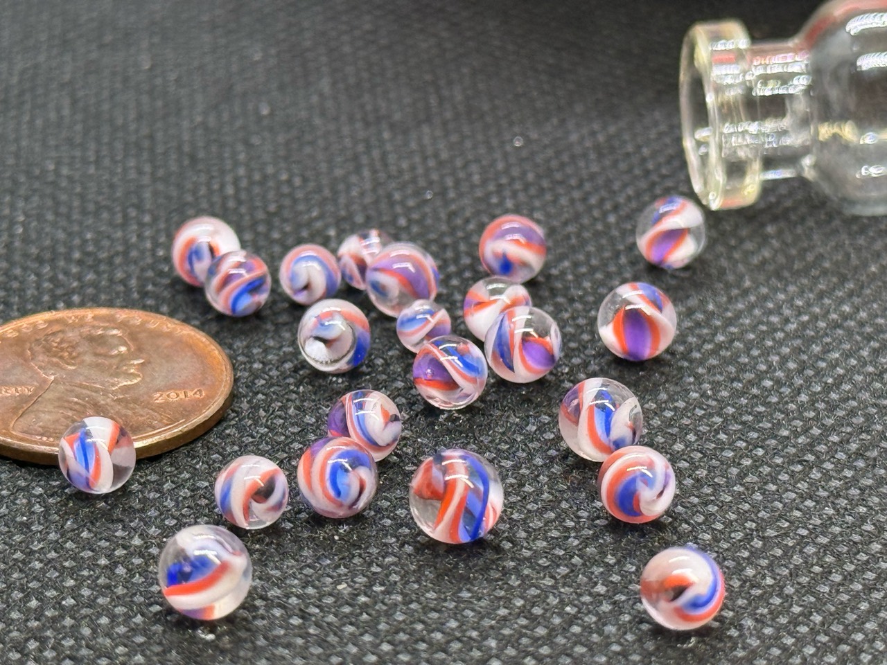 Pink Not Pink Mini Micro Marbles beside a penny for scale