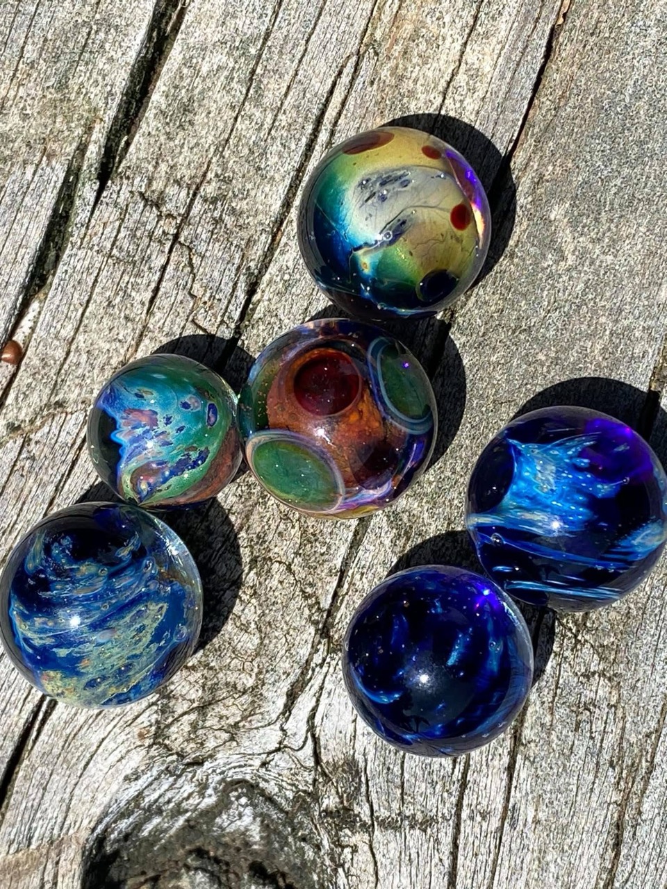 Planetary Space Pocket Marbles — Set #2: complete six-marble set on weathered wood in sunlight