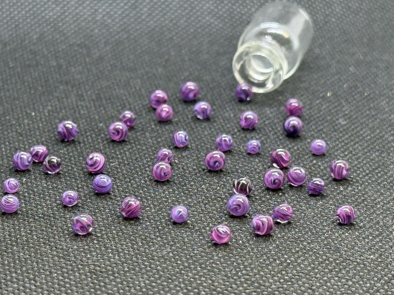 Full view of loose Purple Dream Mini Micro Marbles and their open jar