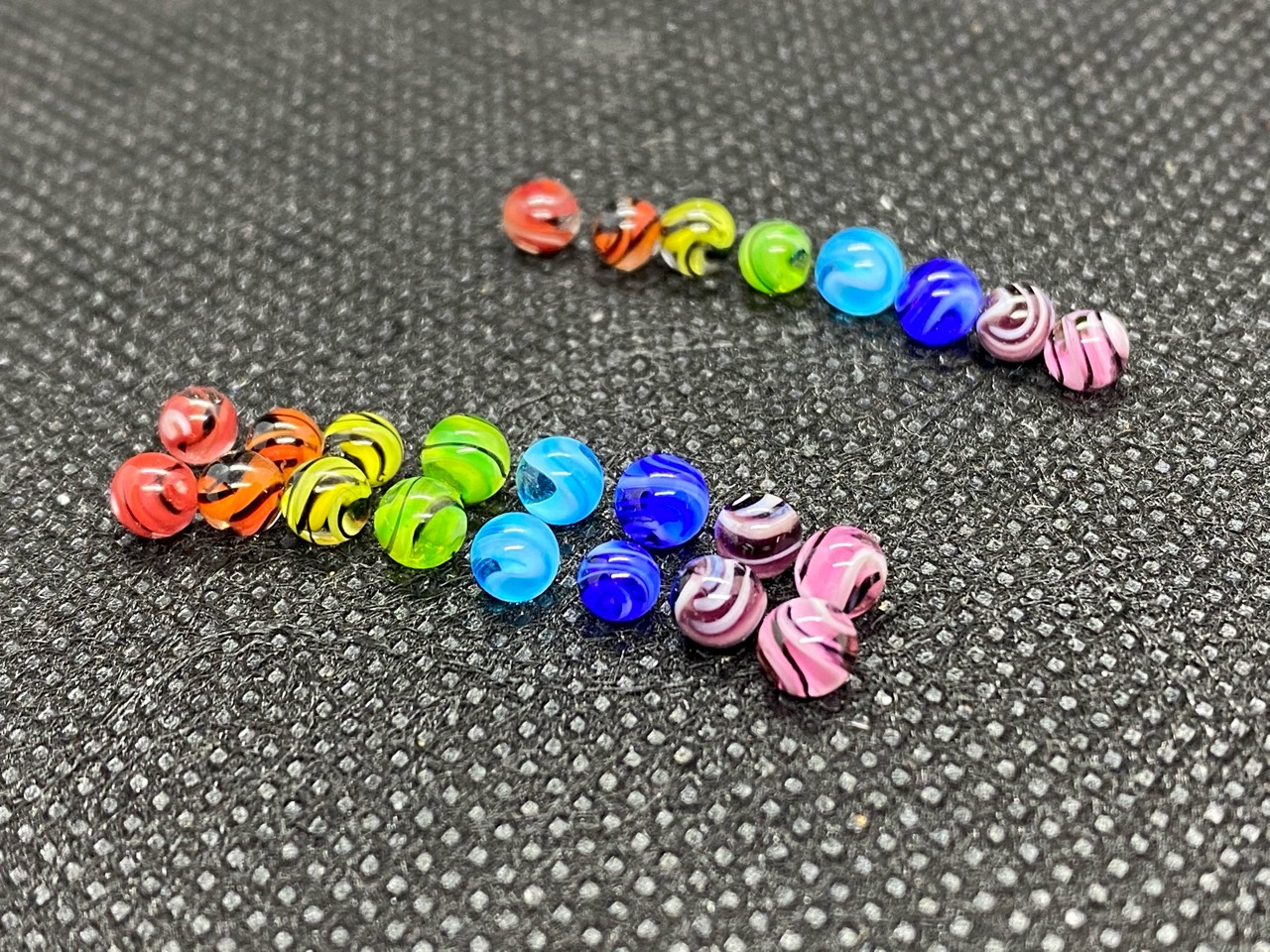 Rainbow Swirl Mini Micro Marbles: Close group view of colorful micro marbles arranged in rainbow rows