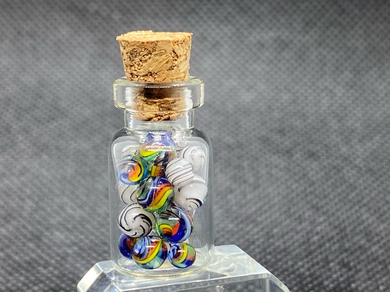 Rainbows & White Tigers Mini Micro Marbles: Corked bottle pairing vivid rainbow micro marbles with white marbles traced by fine dark tiger stripes