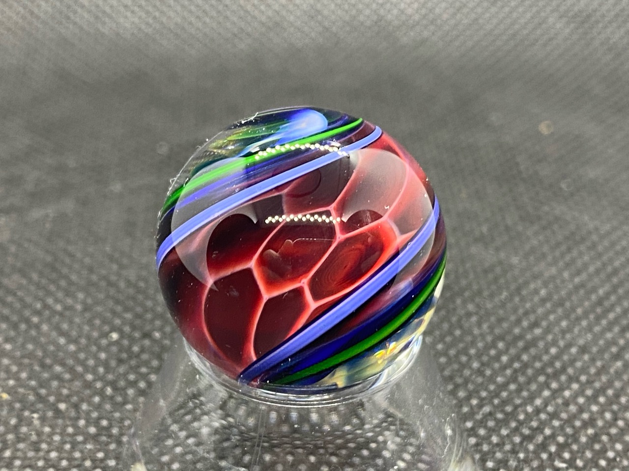 Ruby & Cobalt Ribbon Pocket Marble: Close view of ruby-red cells bordered by lavender and green ribbons