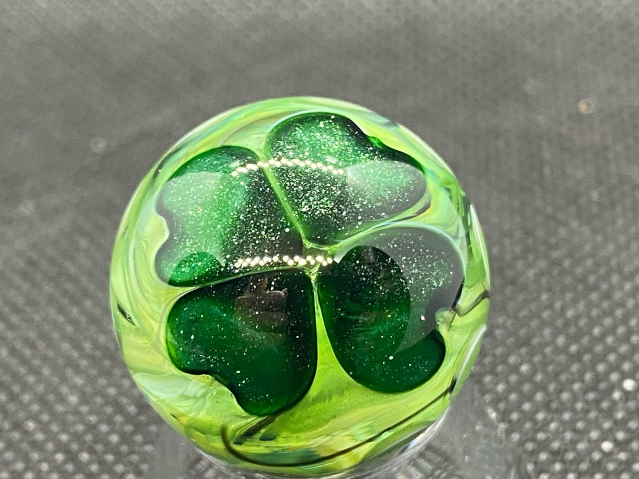 Shamrock Four-Leaf Clover Pocket Marble: Close view of the sparkling green four-leaf clover in yellow-green glass