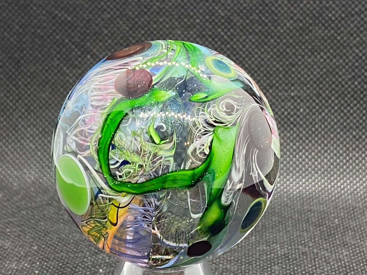 Traditional End of Day Marble: Full view of green ribbon loops, fine white curls and colorful circular forms