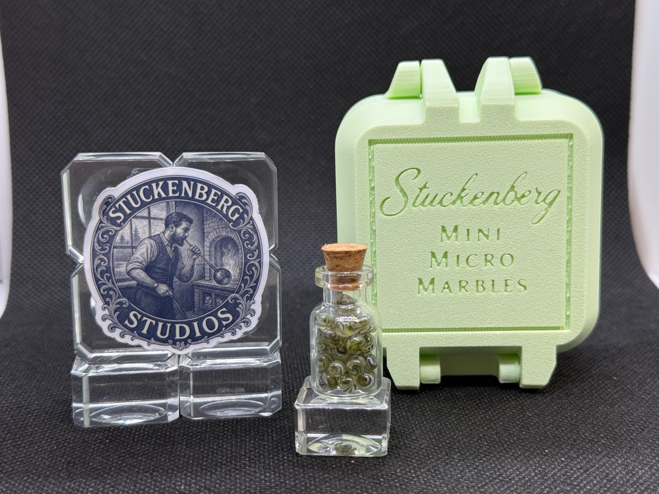 Front view of the UV Champagne marble jar beside studio branding and a pale green hard case in ordinary light